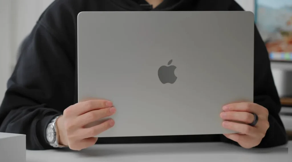 Holding a Starlight MacBook Air: